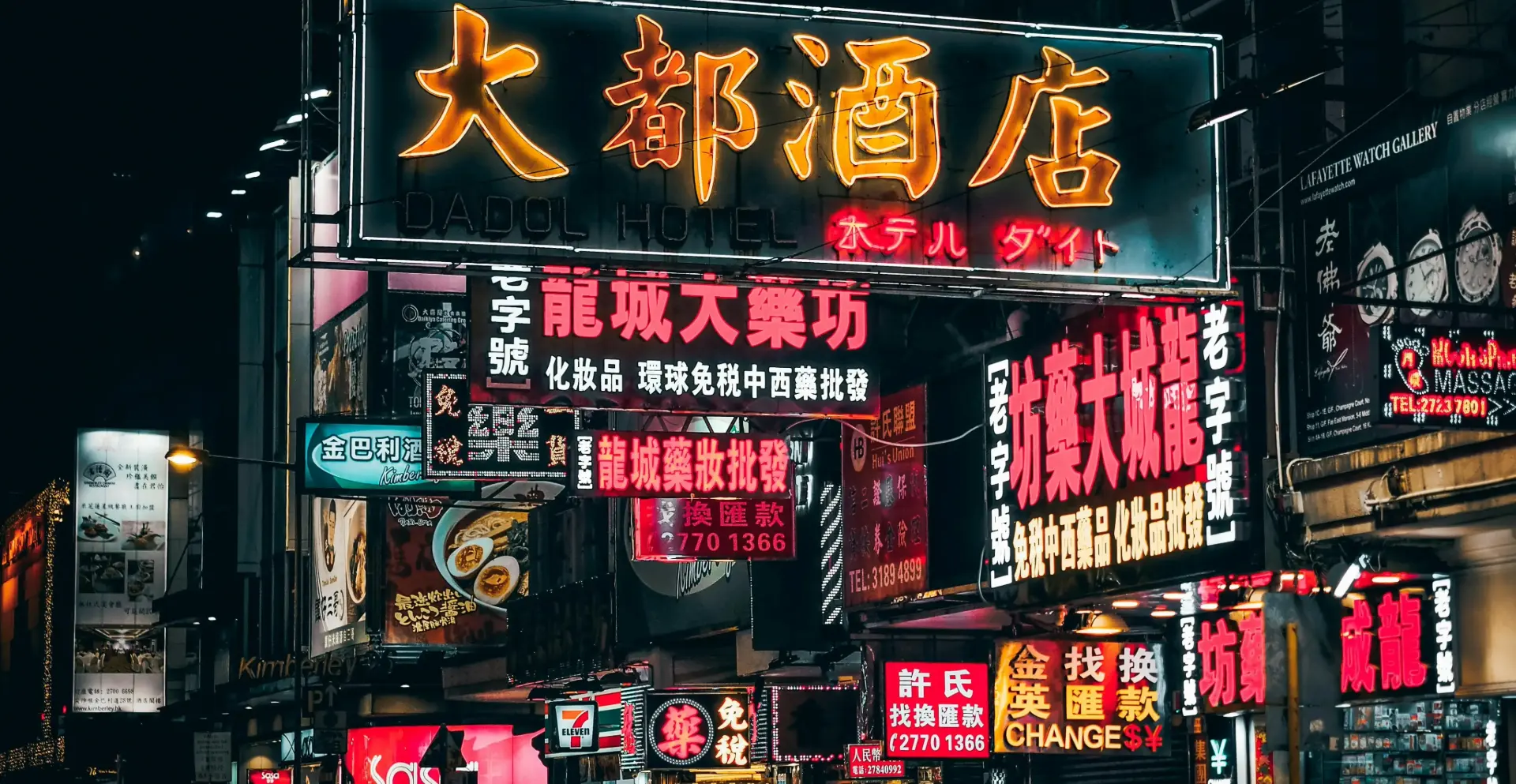 Pantalla LED envolvente sobre fachada de edificio contemporáneo, con publicidad de rostro femenino e iluminación cálida. Perfecta para marcas de moda o tecnología.